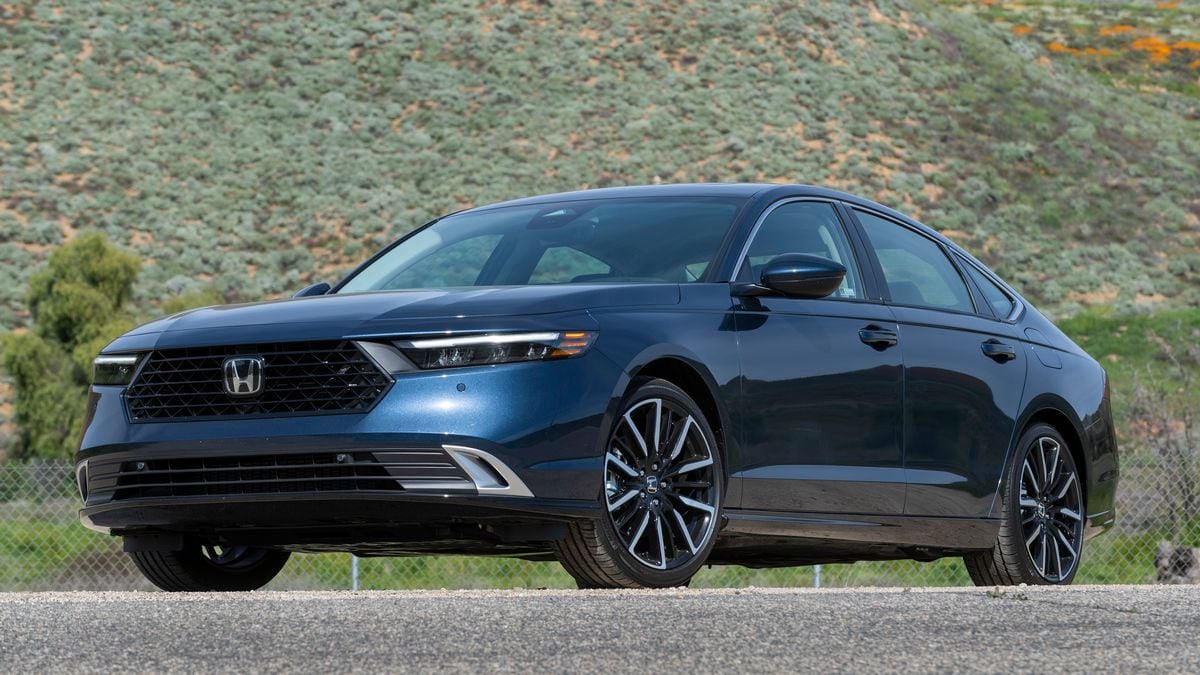 2024 Honda Accord Hybrid with a green hill in the background.