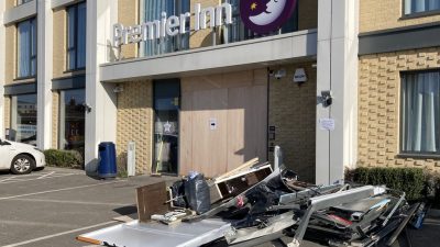 Piled up debris including broken metal and glass panels from the front doors outside the premier inn.