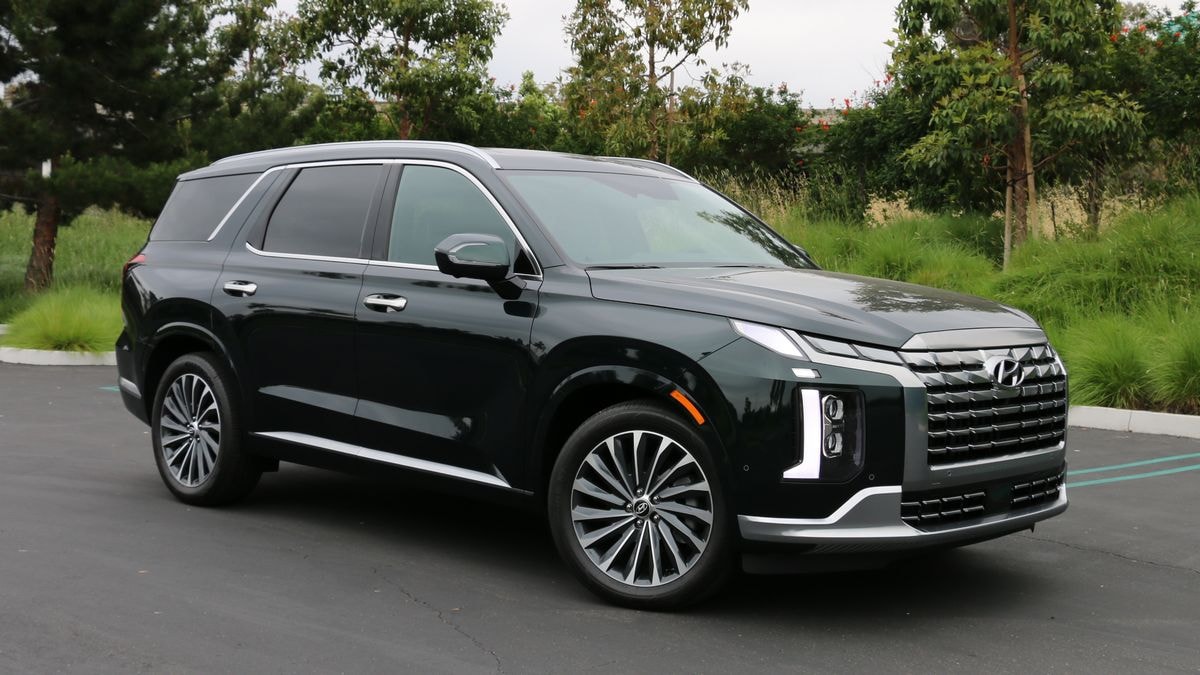 2024 Hyundai Palisade in emerald green near grass and trees.