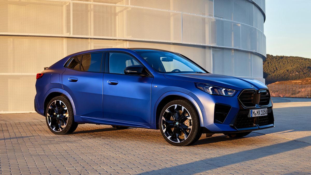 2024 BMW X2 M in blue next to a water tank.